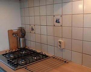 Stijlvolle kookplaat en tegelwand in de keuken van Bij De Vuurtoren appartement, Hollum, Ameland.