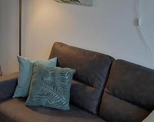 Moderne woonkamer met kunstwerk in Bij De Vuurtoren appartement, Hollum, Ameland.