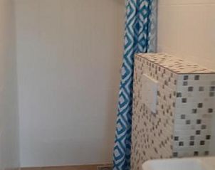 Moderne badkamer met douche en toilet in Bij De Vuurtoren appartement, Hollum, Ameland.