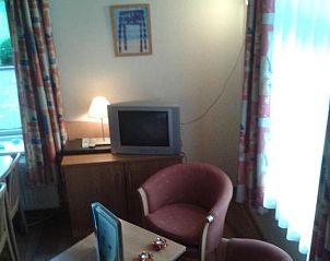 Knusse zithoek met televisie in Bij De Vuurtoren appartement, Hollum, Ameland.