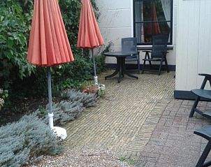 Gezellig terras met parasols bij Bij De Vuurtoren appartement, Hollum, Ameland.