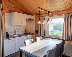 Eetkamer met uitzicht in Finse bungalow 5 personen in Hee, Terschelling, perfect voor gezellige maaltijden.