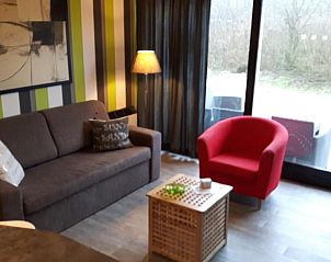 Gezellige woonkamer in Appartement HELIOS - Amelander Kaap met ZWEMBAD, Hollum, Ameland, met comfortabele zitplaatsen en uitzicht.