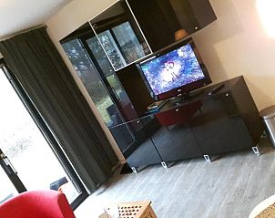 Moderne woonkamer met televisie in Appartement HELIOS - Amelander Kaap met ZWEMBAD, Hollum, Ameland, voor ontspanning.
