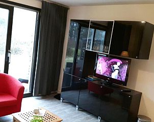 Gezellige zithoek in Appartement HELIOS - Amelander Kaap met ZWEMBAD, Hollum, Ameland, met comfortabele stoelen en tv.