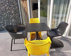 Terrasmeubilair in Appartement HELIOS - Amelander Kaap met ZWEMBAD, Hollum, Ameland, met kleurrijke stoelen en tafel.
