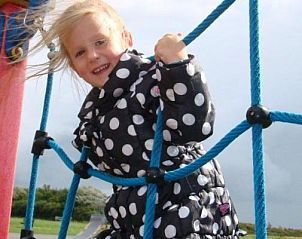 Ein Kind spielt auf dem Spielplatz im Apartment APHRODITE, Hollum, Ameland, und hat Spa.
