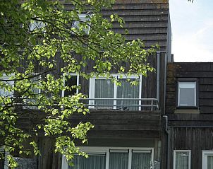 Balkon van Hollumerstrand appartement, Hollum, Ameland, met uitzicht op groene omgeving.