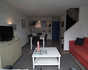 Open woonkamer en keuken in Hollumerstrand appartement, Hollum, Ameland, met moderne inrichting.