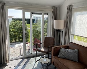 Lichte woonkamer van chalet Wolkenpracht met uitzicht op terras in Halfweg.