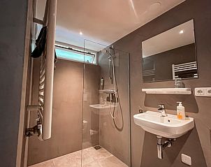 Moderne badkamer in Huisje in Hoorn Terschelling, voorzien van glazen douche en wastafel, Terschelling.