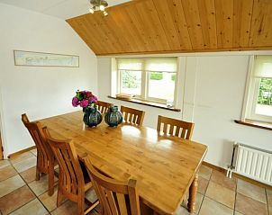 Eetkamer in Appartementenboerderij de Hek Oost, Hoorn, Terschelling met houten tafel en stoelen.