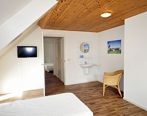 Slaapkamer met wastafel in Appartementenboerderij de Hek Oost, Hoorn, Terschelling voor extra comfort.
