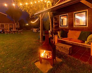 Sfeervol terras bij Kip 2 in Hoorn, Terschelling met avondverlichting en een knusse buitenhaard.