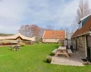 Uitgestrekte groene tuin bij Kip 2, Hoorn, Terschelling met gezellige zitjes en overkapping.