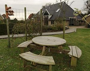Relax in the garden of the Boerderij, a vacation home in Hoorn, Terschelling, with a cozy picnic table.