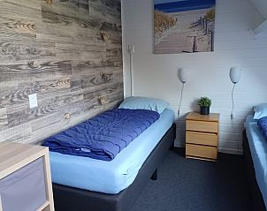 Knusse slaapkamer in Vakantiehuisje in Oosterend, Terschelling, met houten details.