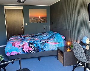 Sfeervolle slaapkamer in Vakantiehuis in Oosterend, Terschelling met modern interieur en kunstwerk.