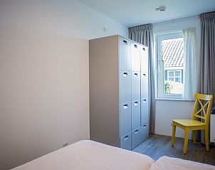 Lichte slaapkamer met uitzicht in Appartement sauna, Oosterend, Terschelling. Ontspan in de serene omgeving van de Waddeneilanden.