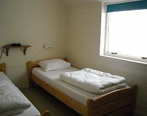 Bedroom with two single beds in De Zicht apartment, West Terschelling.