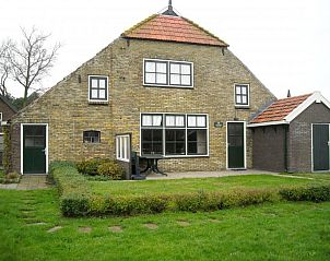 Authentic exterior of De Zicht vacation home in West Terschelling with green garden.