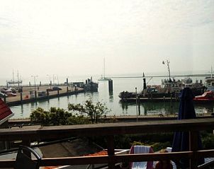 View of the harbor from the terrace of apartment Havenzicht in West, Terschelling, with atmospheric maritime surroundings.