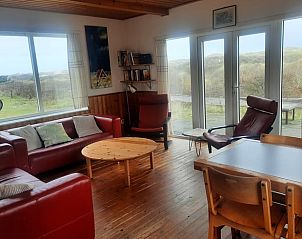 Gezellige woonkamer van Vakantiehuisje in West aan Zee op Terschelling met uitzicht op de duinen en comfortabele zitruimte.