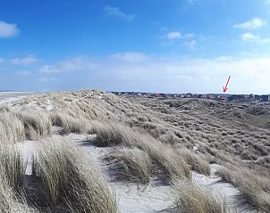 Uitzicht op duinen en Huisje in West aan Zee, vakantiehuis op Terschelling, Waddeneilanden, omringd door prachtige natuur en zandlandschap.
