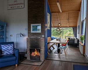 Gezellige woonkamer in Huisje in West aan Zee, Terschelling met open haard en uitzicht op de natuur, ideaal vakantiehuis op de Waddeneilanden.