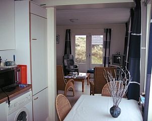 Dining area and kitchen in vacation home Pirola, Midsland aan Zee, ideal for family dinners.