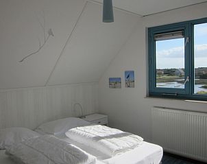 Bright bedroom in Nij Jit vacation home, Midsland aan Zee Terschelling, overlooking water and dunes.