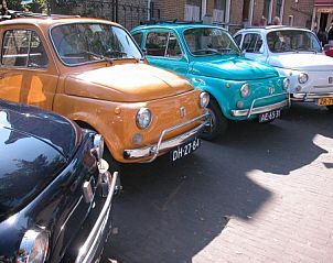 Colorful vintage cars near chalet Hebbes, Midsland Noord, Terschelling. Explore the unique charm of the Wadden Islands.