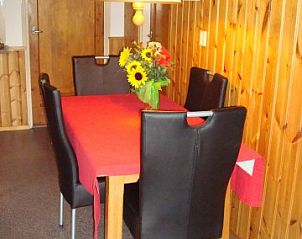 Dining area in bungalow Brunel, Midsland Noord on Terschelling, with wooden accents and flowers.