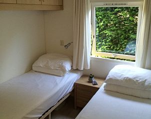 Slaapkamer met twee eenpersoonsbedden in Chalet DOMETO, Midsland Noord, Terschelling, perfect voor een ontspannen verblijf op de Waddeneilanden.
