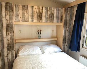 Knusse tweepersoonsslaapkamer in Chalet DOMETO, Midsland Noord, Terschelling, met houten details en een serene sfeer.