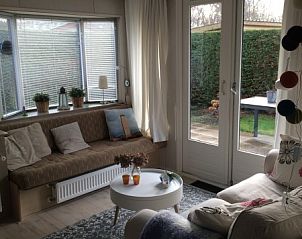 Lichte woonkamer in Chalet DOMETO, Midsland Noord, Terschelling, met uitzicht op de tuin en comfortabele zitmogelijkheden.