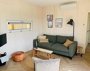 Comfortabele woonkamer van Kleine Walvis vakantiewoning in Midsland Noord, Terschelling met bank en decoratie.