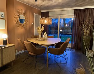 Dining room of Holiday home Belhamel in Midsland Noord, Terschelling with atmospheric lighting and views of the garden.