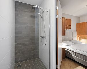 Ruime woonkamer met tv in het 4-persoons appartement 4C2, West-Terschelling, Terschelling, omgeven door natuur.