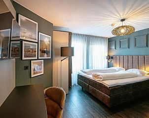 Stijlvolle slaapkamer in Hotel Old Dutch, Volendam, met kunst aan de muur.