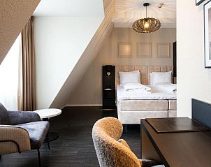 Ruime kamer in Hotel Old Dutch, Volendam, met comfortabele zithoek.