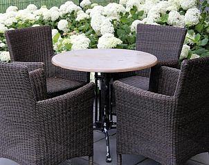 Gezellig zitgedeelte buiten bij Bastion Hotel Utrecht, Utrecht, omringd door groene natuur.