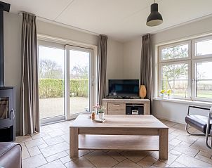 Gezellige woonkamer van De Dijkwachter **** in Ballum, Ameland met moderne inrichting en veel lichtinval.