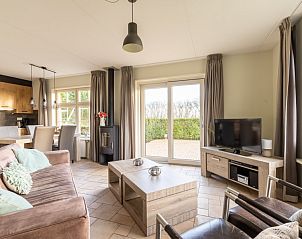 Ruime woonkamer van De Dijkwachter **** in Ballum, Ameland met comfortabele zithoek en uitzicht op de tuin.