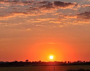 Prachtige zonsondergang over de natuur bij Vakantiehuis in Ballum, Ameland.
