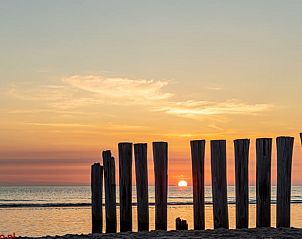 Houten palen bij zonsondergang aan het strand van Ameland, nabij Ballum.