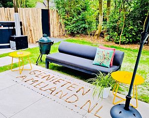 Buitenlounge bij Vakantiehuisje in Ballum, Ameland met comfortabele zitplaatsen en groene omgeving, ideaal voor ontspanning.