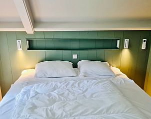 Sfeervolle slaapkamer in Vakantiehuisje in Ballum, Ameland met comfortabel bed en zachte verlichting voor een goede nachtrust.