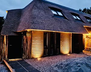 Verlichte entree van Vakantiehuisje in Ballum, Ameland in de avond, biedt een warm welkom op de Waddeneilanden.