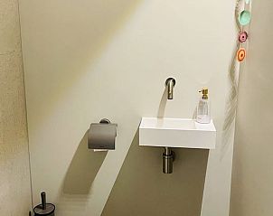 Stijlvolle wastafel en toilet in Vakantiehuisje in Ballum, Ameland, biedt moderne gemakken voor gasten.